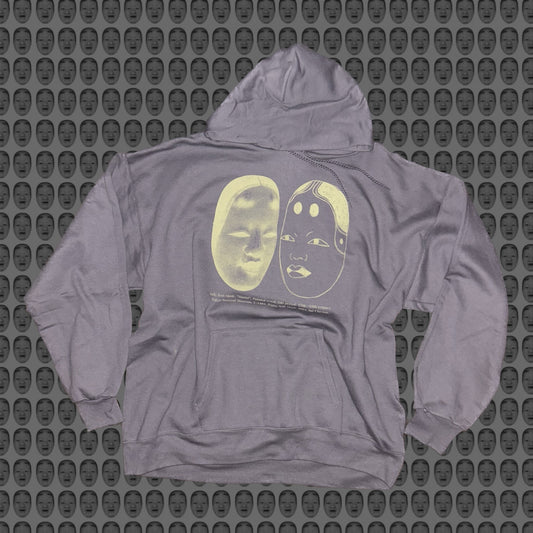 Gray hoodie with a face and noh mask design by STUDIO SAISAI on the front against a patterned background